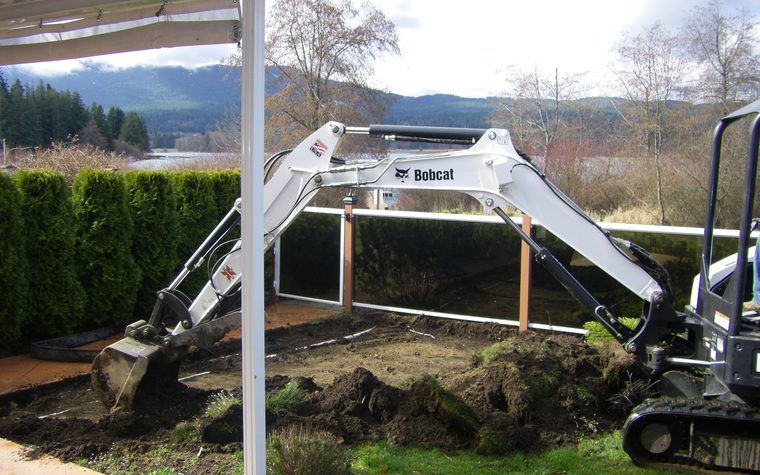 Bobcat excavator digging in a back yard