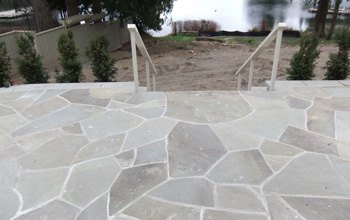 Flagstone patio with steps and railings