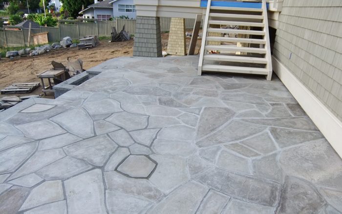 Flagstone patio below a set of deck stairs