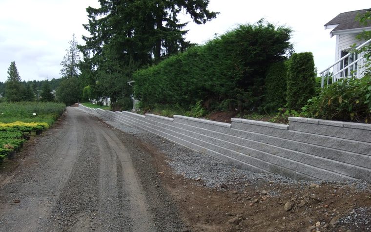 Gravel driveway beside a block retaining wall