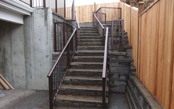 Long run of stairs with railings beside a cedar fence