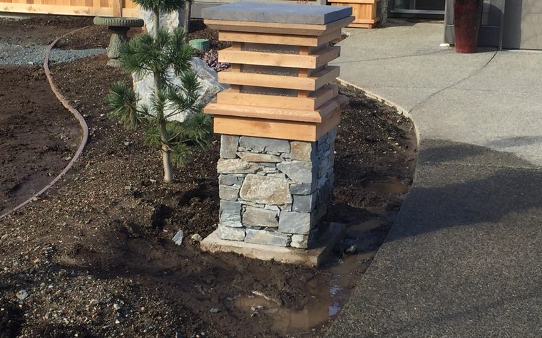 Stone column topped with cedar beside a driveway