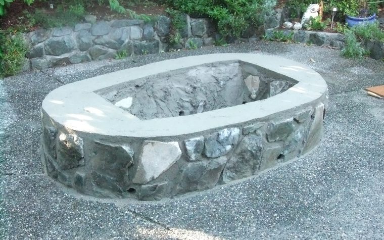 Round stone fire pit on a gravel patio